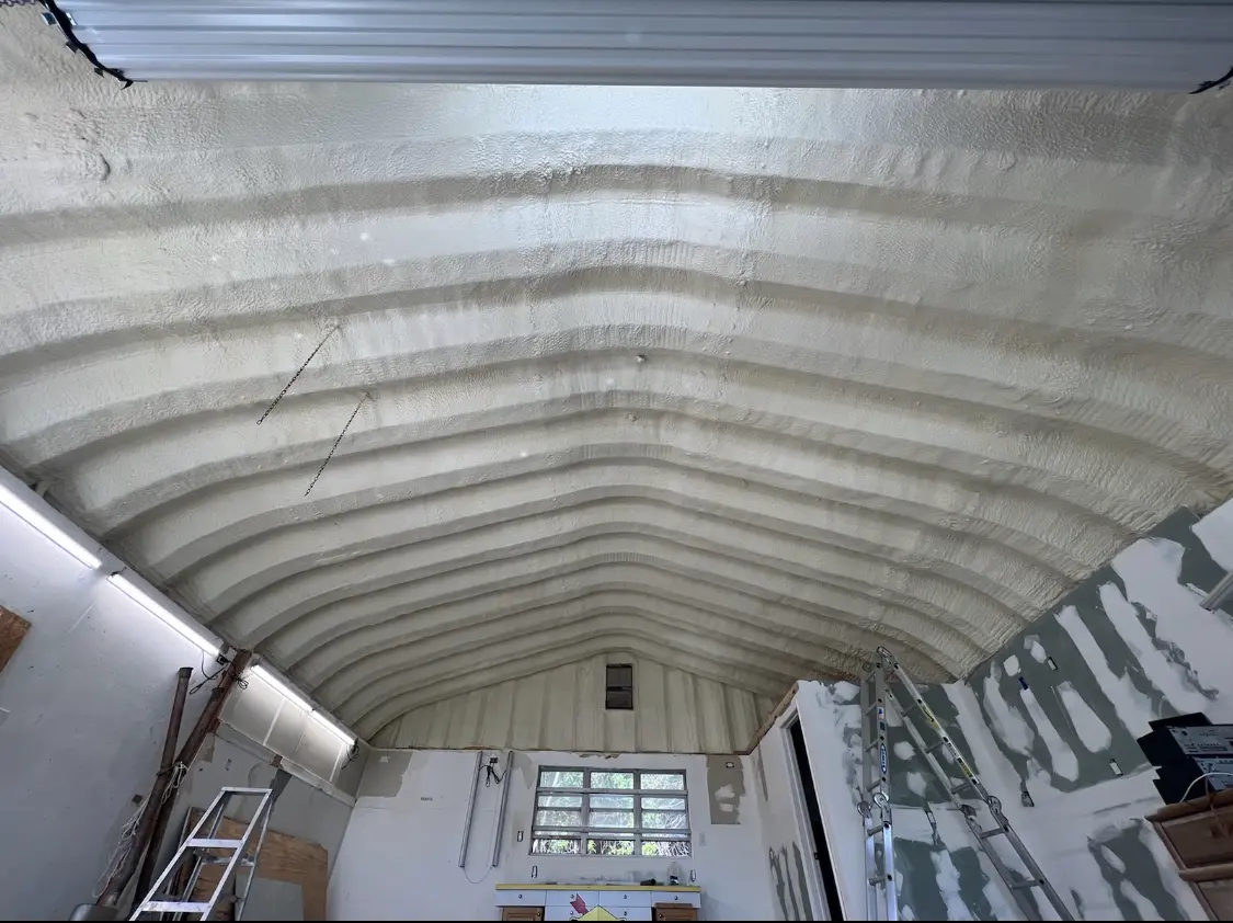 Spray polyurethane foam applied to the underside of a metal roof deck in Johnston